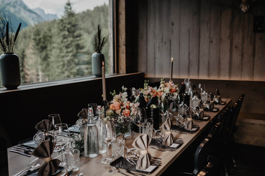 Elegant gedeckter Tisch mit Blumenarrangement und Ausblick auf die Berge in Dienten.