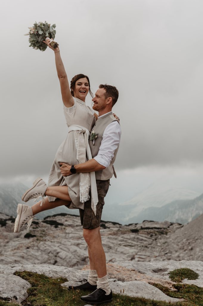 Brautpaar in Tracht feiert Hochzeit vor Alpenpanorama am Hochkönig